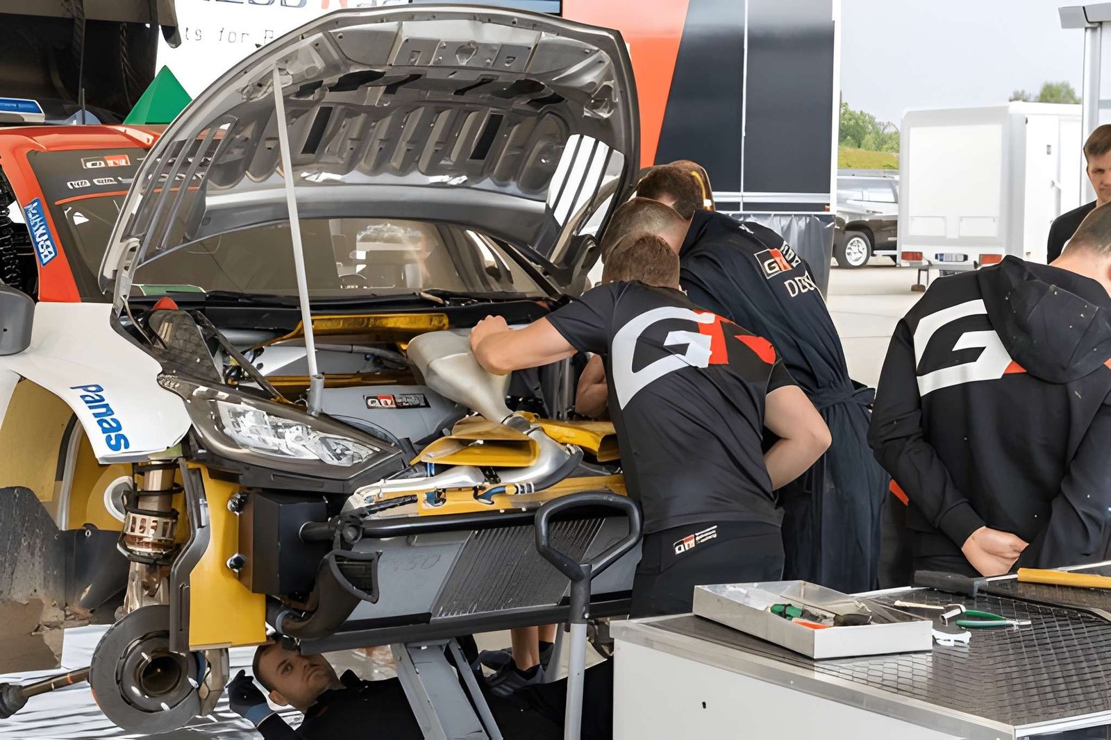 echnicians inspecting and repairing a race car